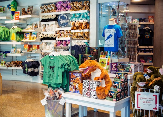 Perot Museum shop full of various items, including t-shirts, stuffed dinosaurs and animals, and toys.