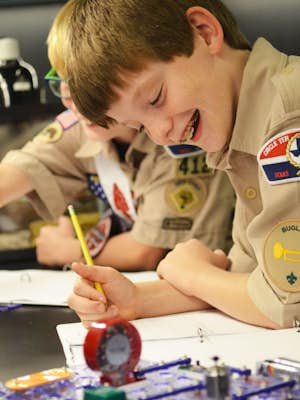 Two boys scouts working on a project at a table